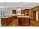 Elegant kitchen featuring custom wood cabinets, granite countertops, stainless steel appliances, and a center island at 104 Bellagio Dr, Apex, NC 27539