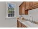 Well-lit laundry room featuring upper cabinets, a sink, and a view of greenery through the window at 104 Bellagio Dr, Apex, NC 27539