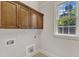 Bright laundry room with wood cabinets and a window offering natural light at 104 Bellagio Dr, Apex, NC 27539