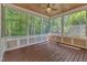 Screened-in porch with wood flooring, ceiling fan, and beautiful wooded views at 104 Bellagio Dr, Apex, NC 27539