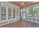 Relaxing screened porch with wood floors, ceiling fan, and large windows offering serene views at 104 Bellagio Dr, Apex, NC 27539