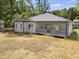 Exterior shot of home showcasing the covered patio with grey railings, grey siding, and grassy yard at 107 Mohave Dr, Louisburg, NC 27549