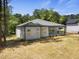 Back exterior of the home showcasing grey siding, covered porch, and spacious grassy yard at 107 Mohave Dr, Louisburg, NC 27549