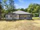 Rear view of the home featuring a grey exterior, covered patio, and a well-maintained backyard at 107 Mohave Dr, Louisburg, NC 27549