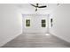 Bedroom featuring gray wood floors, white walls and trim with two windows at 107 Mohave Dr, Louisburg, NC 27549