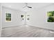 Spacious bedroom features light gray flooring, three windows, and neutral decor at 107 Mohave Dr, Louisburg, NC 27549
