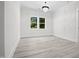 Bright bedroom showcasing light gray flooring, modern chandelier, and natural light at 107 Mohave Dr, Louisburg, NC 27549