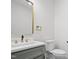 This updated powder room has a modern vanity with gold hardware and fixtures, with a contrasting neutral color palette at 107 Mohave Dr, Louisburg, NC 27549