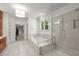 A luxurious bathroom features a glass-enclosed shower and tub with a view into the walk-in closet at 109 Greenock Ct, Cary, NC 27511