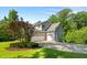 Rear of the property featuring a three-car garage and a well-manicured lawn at 109 Greenock Ct, Cary, NC 27511