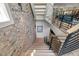 A modern staircase with metal railings and brick accent wall leading to the upper level at 109 Greenock Ct, Cary, NC 27511