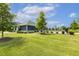 Manicured front yard with green lawn, beautiful trees, and a fenced pool area at 1141 Duke Farm Dr, Wake Forest, NC 27587