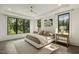Bright main bedroom boasts tray ceilings, hardwood floors, and large windows overlooking lush greenery at 1141 Duke Farm Dr, Wake Forest, NC 27587