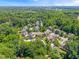 An aerial shot of a lush, green neighborhood with mature trees and well-maintained homes offers a serene living environment at 118 Fox Run Ct, Durham, NC 27705