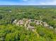 Aerial view shows a green neighborhood with mature trees, and homes nestled in a serene landscape at 118 Fox Run Ct, Durham, NC 27705