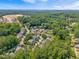 Aerial view showcases a charming neighborhood surrounded by lush greenery and mature trees, with homes nestled in a serene landscape at 118 Fox Run Ct, Durham, NC 27705