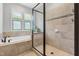Bright bathroom featuring a glass-enclosed shower and soaking tub with natural light at 118 Fox Run Ct, Durham, NC 27705