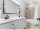 Bathroom featuring double sinks, white cabinets, and tile tub-shower surround at 118 Fox Run Ct, Durham, NC 27705
