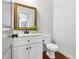 Elegant half bathroom with a marble countertop and a stylish gold-framed mirror at 118 Fox Run Ct, Durham, NC 27705