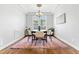 Cozy dining room with hardwood floors, modern lighting, and a large window for natural light at 118 Fox Run Ct, Durham, NC 27705