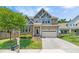 Stunning home with stone accents, lush landscaping, and an attached two-car garage on a sunny day at 118 Fox Run Ct, Durham, NC 27705