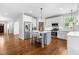 Bright kitchen with stainless steel appliances, white cabinets, island seating, and hardwood floors at 118 Fox Run Ct, Durham, NC 27705