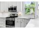 Modern kitchen featuring white cabinets, stainless steel appliances, and a bright window at 118 Fox Run Ct, Durham, NC 27705