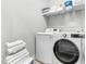 Laundry room with white washer/dryer, shelving, and stacked clean towels at 118 Fox Run Ct, Durham, NC 27705