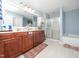 Bathroom with double sinks, wood cabinets, shower and soaking tub at 1209 Partington St, Wake Forest, NC 27587