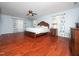 Spacious bedroom with hardwood floors, ceiling fan, a large bed, and floral curtains at 1209 Partington St, Wake Forest, NC 27587