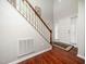 A bright foyer with hardwood floors, white door, and stairs with wooden railing at 1209 Partington St, Wake Forest, NC 27587