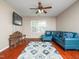 Open living area featuring a blue leather sofa, hardwood floors, and a stylish patterned rug at 1209 Partington St, Wake Forest, NC 27587