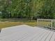Serene backyard view with a white deck, green lawn, trees, and a chain-link fence at 1230 Piney Glen Ln, Zebulon, NC 27597