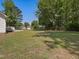 Expansive backyard with mature trees, a chain-link fence, and a detached structure at 1230 Piney Glen Ln, Zebulon, NC 27597