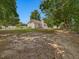 Backyard view of a white home, storage shed, and chain-link fence surrounded by mature trees at 1230 Piney Glen Ln, Zebulon, NC 27597
