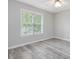 Bedroom with wood-look flooring, a ceiling fan, and a large window for natural light at 1230 Piney Glen Ln, Zebulon, NC 27597