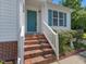 Welcoming entrance with a vibrant door, brick steps and trimmed landscaping at 1230 Piney Glen Ln, Zebulon, NC 27597