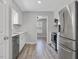 Modern kitchen with white cabinets, stainless steel appliances, and gray wood floors at 1230 Piney Glen Ln, Zebulon, NC 27597