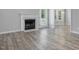 Living room with marble fireplace, gray wood flooring, and natural light, blending comfort and style at 1230 Piney Glen Ln, Zebulon, NC 27597