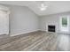 Spacious living room with vaulted ceiling, fireplace and gray wood flooring provides modern comfort and style at 1230 Piney Glen Ln, Zebulon, NC 27597