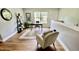 This is a well-lit home office space with an armchair and large area rug at 126 Willow Weald Ct, Fuquay Varina, NC 27526