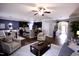 Open-concept living room showcases wood floors, ceiling fan, cozy furniture, and seamless flow into the kitchen and dining area at 126 Willow Weald Ct, Fuquay Varina, NC 27526