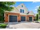 Three-car garage with brick facade and yellow siding, enhances curb appeal with charming landscaping at 127 Bobwhite Way, Mebane, NC 27302