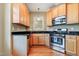 A gourmet kitchen with stainless appliances, wood cabinets, hardwood floors, and granite countertops; culinary dreams await at 127 Bobwhite Way, Mebane, NC 27302