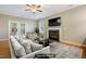 Cozy living room with a fireplace, plush seating, and natural light from French doors at 127 Bobwhite Way, Mebane, NC 27302