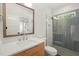 Bathroom featuring wood vanity, sleek sink, stylish mirror, and glass-enclosed shower with herringbone tile at 1409 Montvale Ridge Dr, Cary, NC 27519