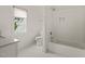 Bright bathroom featuring white tile, a window, a toilet, a tub and shower, and a granite countertop at 1409 Montvale Ridge Dr, Cary, NC 27519