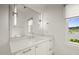 Bright bathroom with a large mirror, stone countertops, and a window with views of the outdoors at 1409 Montvale Ridge Dr, Cary, NC 27519
