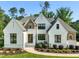 Charming two-story home featuring white brick, black framed windows, manicured landscaping, and a concrete walkway at 1409 Montvale Ridge Dr, Cary, NC 27519