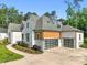 A modern house displaying stylish garage doors, white siding and brick, complemented by manicured landscaping at 1409 Montvale Ridge Dr, Cary, NC 27519